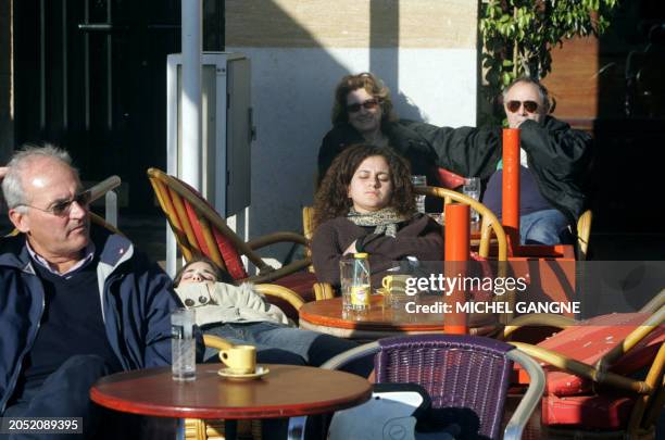 Des personnes profitent de la douceur des températures qui avoisine les 20 degés celsius, le 10 janvier 2007 à une terrasse du centre ville de...