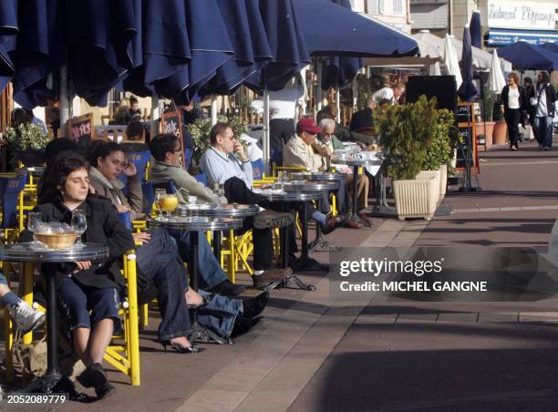 Des personnes profitent de la douceur des températures qui avoisine les 20 degés celsius, le 10 janvier 2007 à une terrasse du centre ville de...