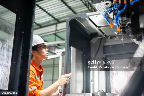 hispanic technician showcasing mastery in configuring a cutting-edge cnc milling machine for precision manufacturing. - configuring stock pictures, royalty-free photos & images