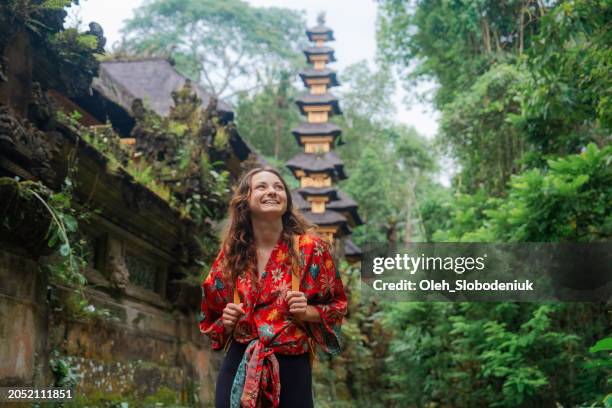 mujer caminando por el templo en las selvas de bali - bali fotografías e imágenes de stock