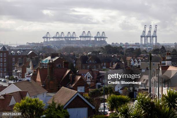 Gantry cranes at the Port of Felixstowe, owned by a unit of CK Hutchison Holdings Ltd., beyond residential housing in Felixstowe, UK, on Monday,...
