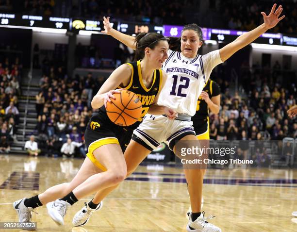 Iowa's Caitlin Clark drives to the basket while being guarded by Northwestern's Casey Harter in the second half at Welsh-Ryan Arena on Jan. 31 in...