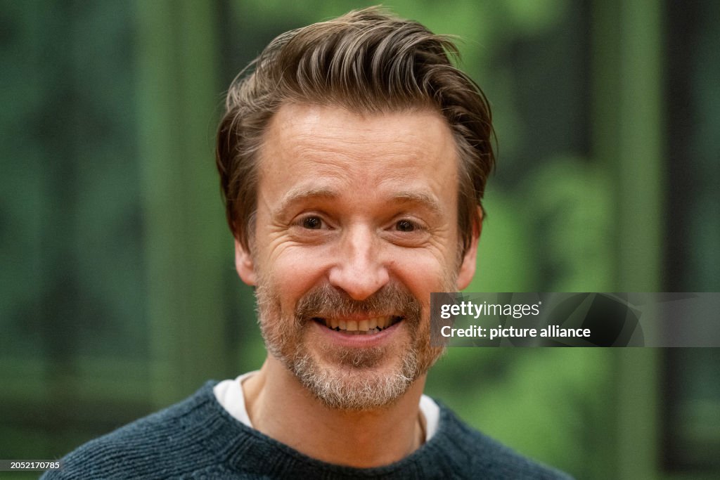 Max von Pufendorf, actor, stands in front of a theater backdrop from