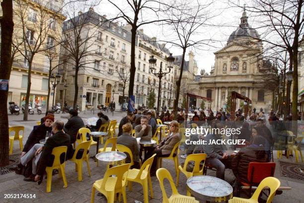 Des personnes profitent des températures particulièrement douces pour la saison sur des terrasses de café, le 05 février 2004 à Paris. AFP PHOTO JACK...