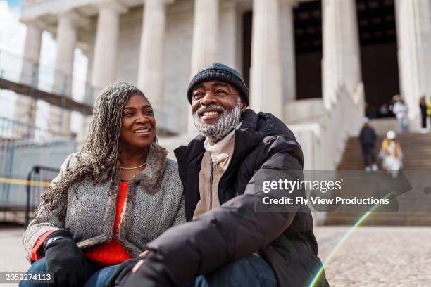 vibrant senior black couple sitting on the steps of the lincoln memorial in washington dc - washington dc winter stock pictures, royalty-free photos & images