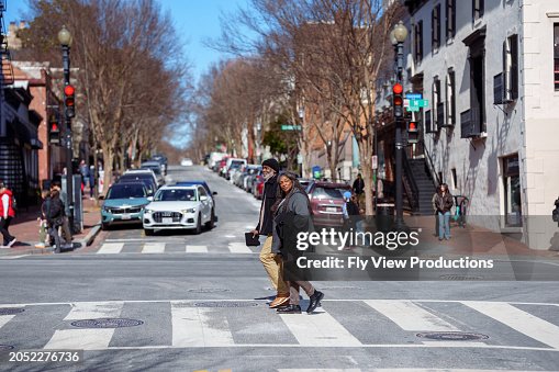 Active senior couple crossing the street while exploring Washington DC in the winter