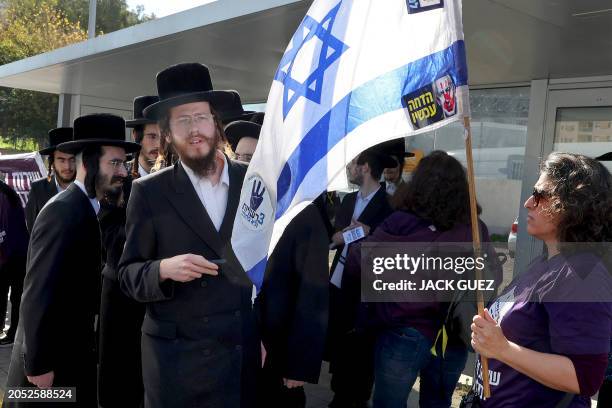 Israeli protesters confront Ultra-Orthodox Jewish men outside an army recruiting office in the town of Kiryat Ono near Tel Aviv on March 5 during a...