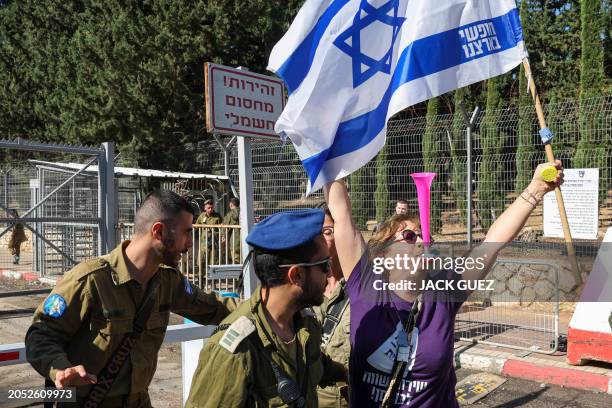 An Israeli protester waves her national flag outside an army recruiting office in the town of Kiryat Ono near Tel Aviv on March 5 during a...