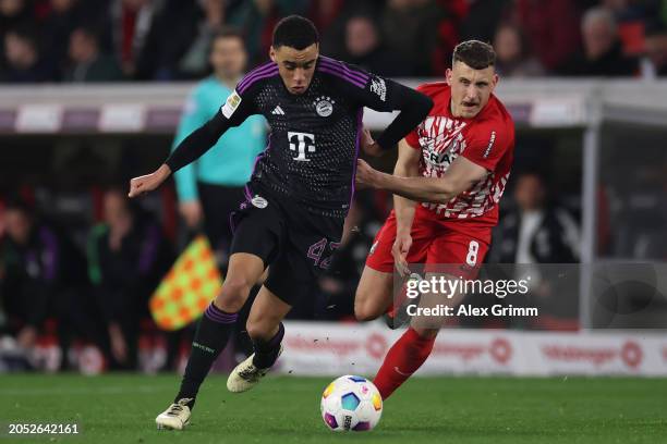 Jamal Musiala of Bayern Muenchen eludes Maximilian Eggestein of Freiburg during the Bundesliga match between Sport-Club Freiburg and FC Bayern...