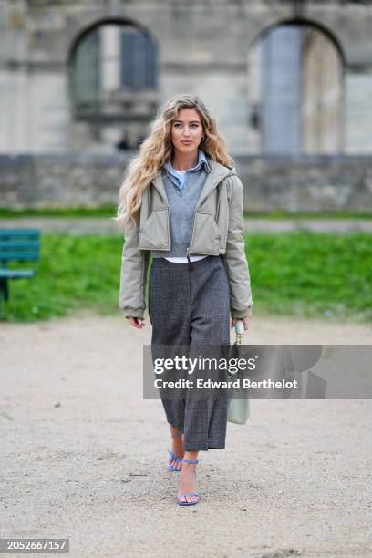 Emili Sindlev wears a beige cropped puffer jacket , a blue shoes , a gray midi skirt, a pastel pale green bag in gathered leather , blue shoes,...