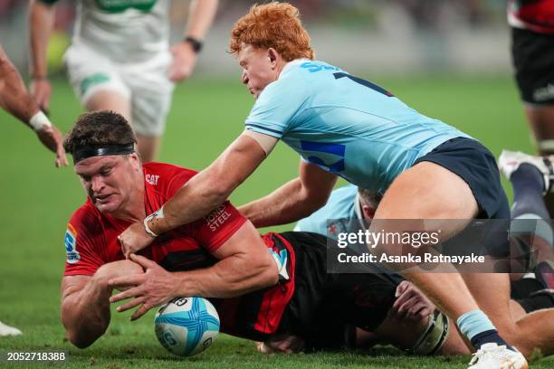 Tane Edmed of the Waratahs tackles Scott Barrett of the Crusaders on the try line during the round two Super Rugby Pacific match between Crusaders...