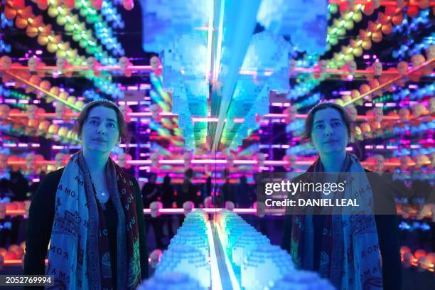 Gallery assistant poses with an artwork by US Lego artist Nathan Sawaya, during an exhibition of his work entitled 'Art of the Brick', in Brick Lane,...