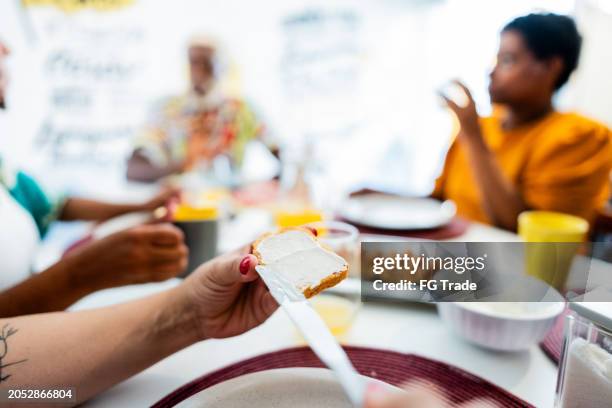 close-up of a woman putting butter on bread on hotel restaurant - butter knife stock pictures, royalty-free photos & images