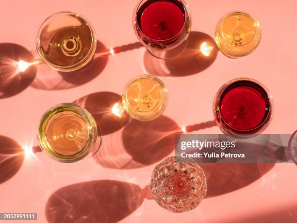 wine glasses on a pink background in the sunlight - wine stockfoto's en -beelden