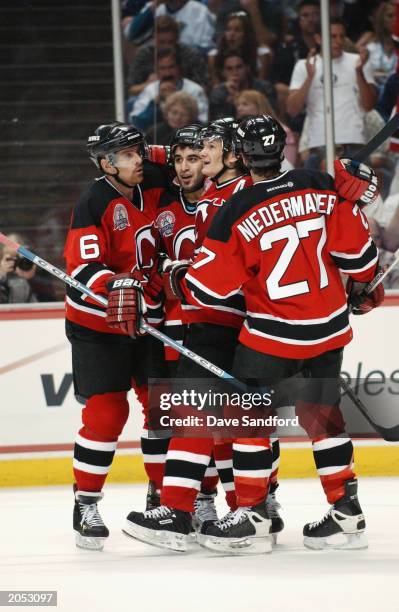 Scott Gomez of the New Jersey Devils is congratulated by teammates Tommy Albelin, Patrik Elias and Scott Niedermayer after scoring a goal against the...