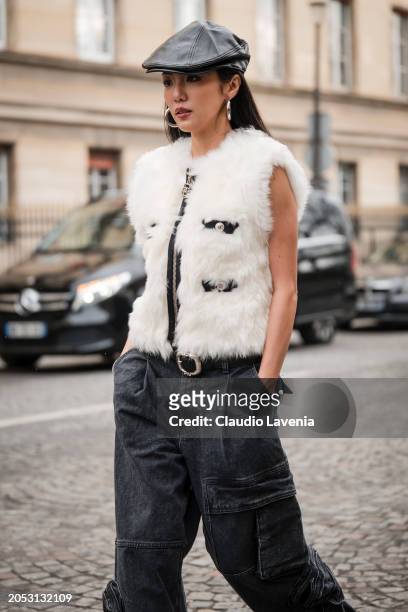 Yoyo Cao wears white fur vest, black cargo jeans, black leather beret, outside Giambattista Valli, during the Womenswear Fall/Winter 2024/2025 as...