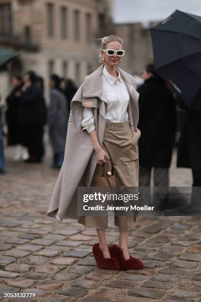 Leonie Hanne was seen wearing beige skirt, red fluffy shoes, beige shades, white top and beige coat before the Loewe Fashion Show during the...