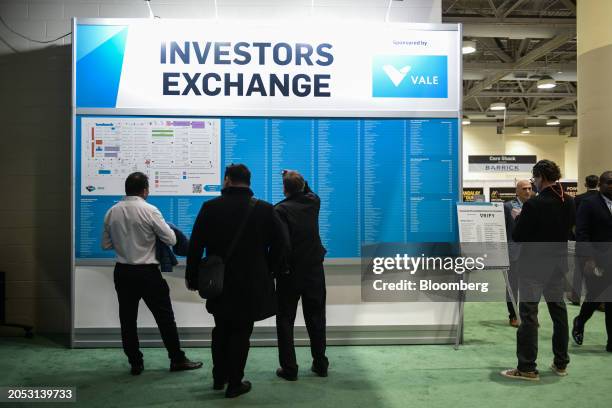 Attendees check the Investors Exchange map at the entrance to an exhibit hall during the Prospectors & Developers Association of Canada conference in...