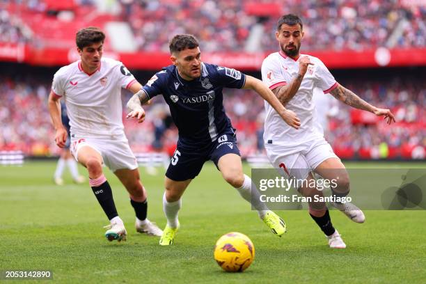 Javi Galan of Real Sociedad is challenged by Suso and Juanlu Sanchez of Sevilla FC during the LaLiga EA Sports match between Sevilla FC and Real...