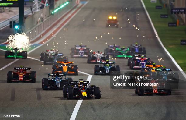 Max Verstappen of the Netherlands driving the Oracle Red Bull Racing RB20 leads Charles Leclerc of Monaco driving the Ferrari SF-24 and the rest of...