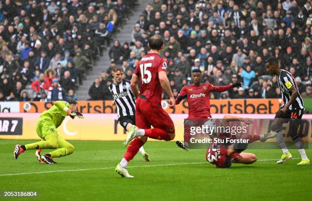 Anthony Gordon of Newcastle United scores his team's second goal as Nelson Semedo and Max Kilman of Wolverhampton Wanderers fail to block the shot...