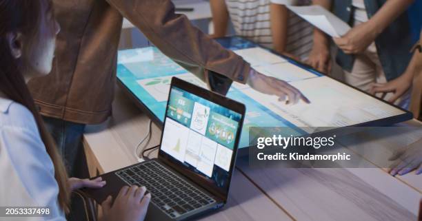 asian business people team brainstorm meeting in sustainable office at night, using computer monitor. discuss esg (environmental social corporate governance) project planning. responsible organization - climate finance stock pictures, royalty-free photos & images