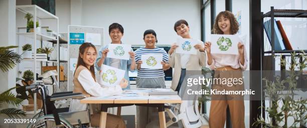 group portrait of young millennial generation z business people hold recycle symbol with smile. net zero, waste recycling campaign, carbon neutrality global warming, environmental conservation concept - young students campaign to create awareness on world earth day stockfoto's en -beelden