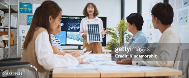 asian business people team brainstorm meeting in sustainable corporate office. presentation esg project planning, solar panel, wind turbine power energy generation. environmental conservation concept - zeichentrickaufnahme stock-fotos und bilder