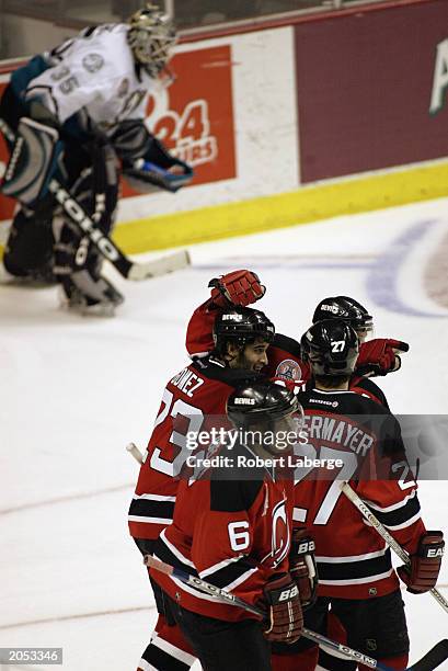 Scott Gomez of the New Jersey Devils is congratulated by teammates after scoring the tying goal as Jean-Sebastien Giguere of the Mighty Ducks of...