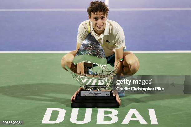 Ugo Humbert of France celebrates victory with the trophy over Alexander Bublik of Kazakhstan in the final match during the Dubai Duty Free Tennis...