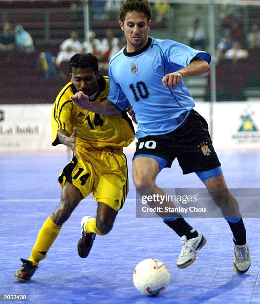 Alvaro Pineiro of Uruguay battles with Mohd Feroz of Malaysia during the 2003 World 5s Futsal Championship between Uruguay and Malaysia on June 03,...