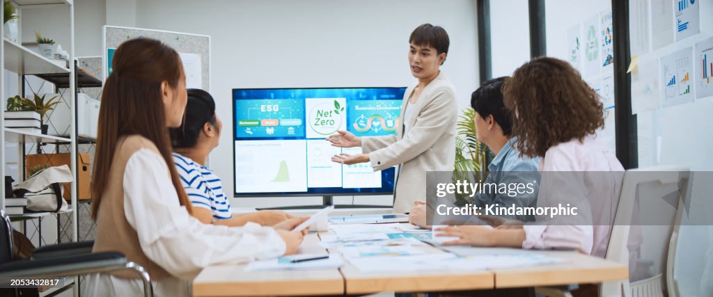 Asian business people team brainstorm meeting in green corporate office. Presentation ESG project planning. Environmental conservation, responsible business, sustainable development goal concept