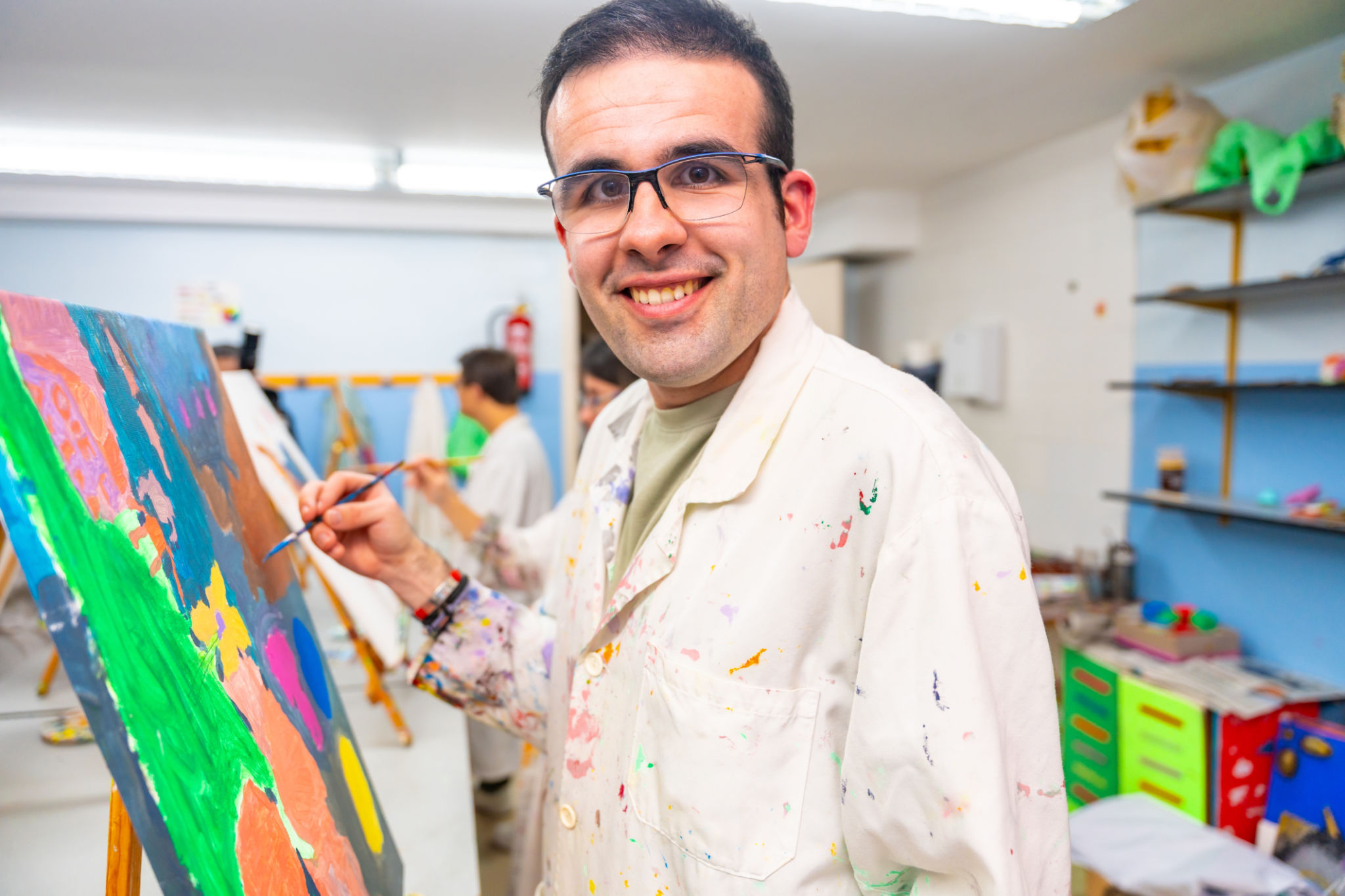 Disabled man happy while painting on canvas Disabled man happy while painting on canvas