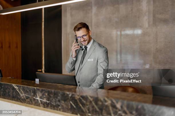 portrait of receptionist talking on phone - receptionsdisk bildbanksfoton och bilder