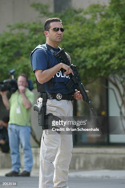 An unidentified U.S. Marshal stands guard as a car carrying Eric Rudolph leaves the federal courthouse June 3, 2003 in Birmingham, Alabama. Rudolph...