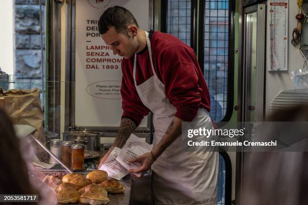 Man prepares sandwiches with lampredotto - a typical Florentine dish, made from the fourth and final stomach of cattle, the abomasum - at the famed...