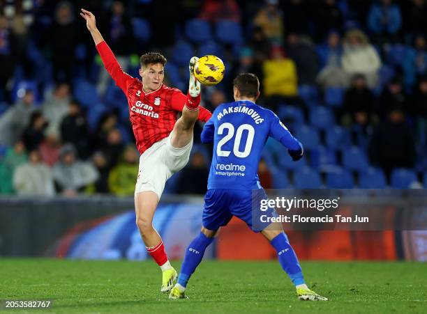 Mika Marmol of UD Las Palmas controls the ball the ball in the air under pressure from Nemanja Maksimovic of Getafe CF during the LaLiga EA Sports...