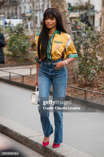 Kenza Boutrif wears colored printed shirt, jeans, red heels, cream Chanel bag, outside Casablanca, during the Womenswear Fall/Winter 2024/2025 as...