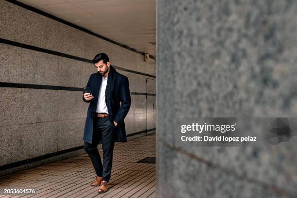 business man checking his smartphone in an urban environment. - grey belt stock pictures, royalty-free photos & images