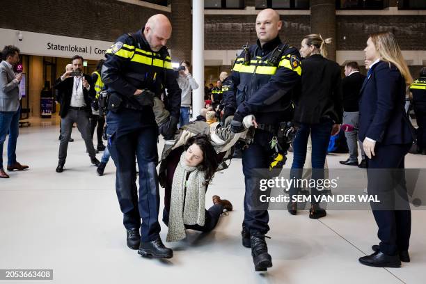 Dutch police officers detain a protestor amid a demonstration in support of Palestinians at the House of Representatives in the Hague, on March 5,...