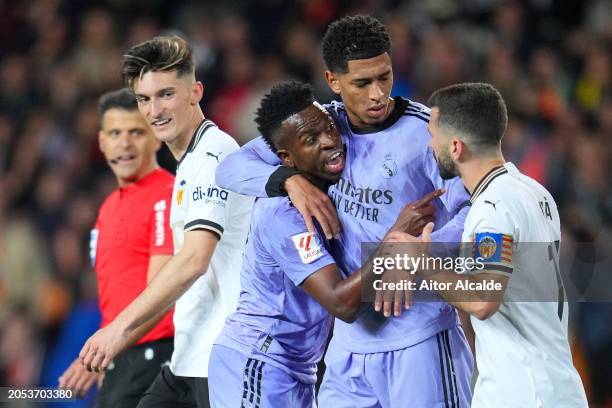Vinicius Junior of Real Madrid clashes with Jose Luis Gaya of Valencia CF as Jude Bellingham of Real Madrid intervenes during the LaLiga EA Sports...