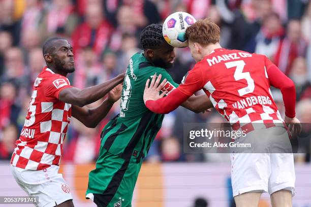 Jordan Siebatcheu of Borussia Moenchengladbach is challenged by Josuha Guilavogui and Sepp van den Berg of Mainz during the Bundesliga match between...