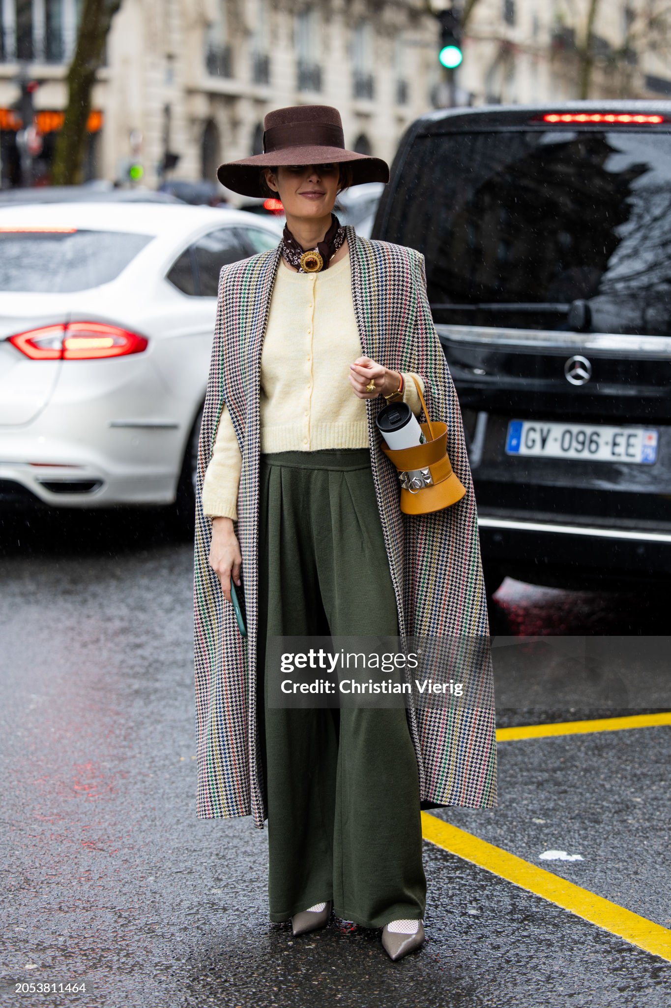 paris-france-maria-de-la-orden-wears-brown-floppy-hat-checkered-cape-green-pants-brown-bag.jpg