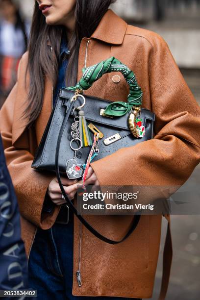 Leia Sfez wears black bag, brown jacket, denim shirt, belt, jeans outside Hermes during the Womenswear Fall/Winter 2024/2025 as part of Paris Fashion...