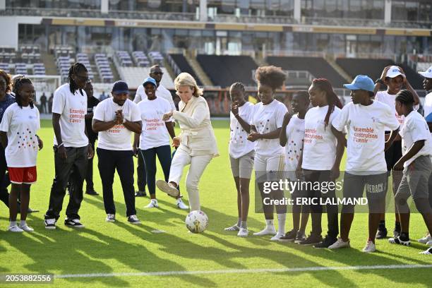 Queen Mathilde of Belgium kicks a ball during a meeting with Ivorian athletes, at the Laurent Poku Stadium in San Pedro, during a royal working visit...