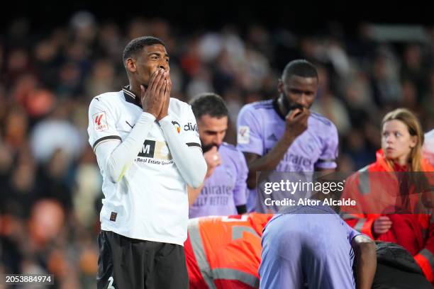 Cristhian Mosquera of Valencia CF reacts as Mouctar Diakhaby of Valencia CF receives medical treatment before being stretchered off the pitch with an...