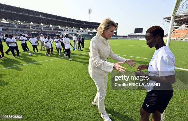 Queen Mathilde of Belgium talks to a young athlete during a meeting with Ivorian athletes, at the Laurent Poku Stadium in San Pedro, during a royal...