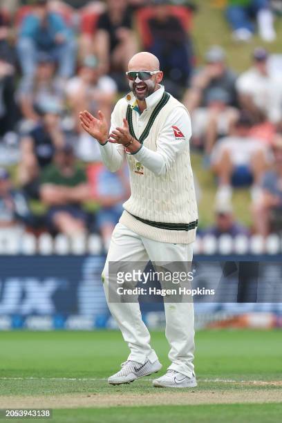 Nathan Lyon of Australia celebrates after taking the wicket of Rachin Ravindra of New Zealand during day four of the First Test in the series between...