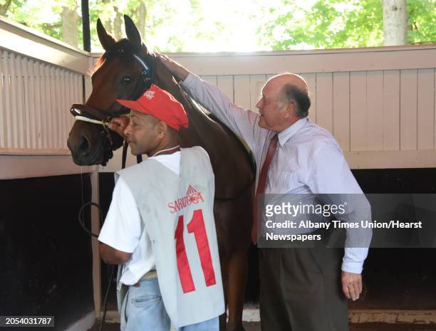 Trainer Jonathan Sheppard gives War Baby a pat of good luck after saddling the race horse for the last race on the last day of the meet at Saratoga...