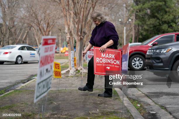 Volunteer puts up a "Mark Robinson Governor" sign outside a polling station at the Wayne County Public Library in Goldsboro, North Carolina, US, on...